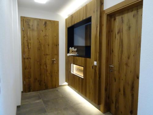 a hallway with two wooden doors and a television at Alpenresidenz M Vermietungs KG in See