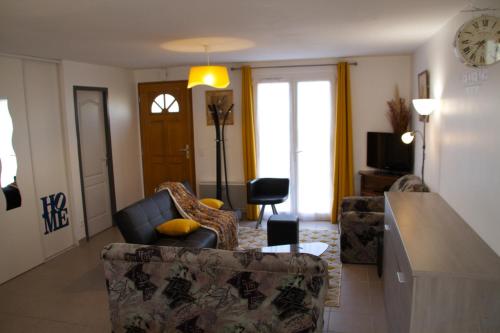 een woonkamer met 2 stoelen en een tafel bij Les lauriers de Lomagne in Lavit