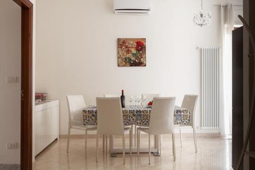 een eetkamer met een tafel en witte stoelen bij Casa Lucia in Lecce