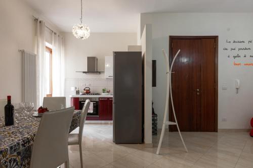 una cucina e una sala da pranzo con tavolo e frigorifero di Casa Lucia a Lecce