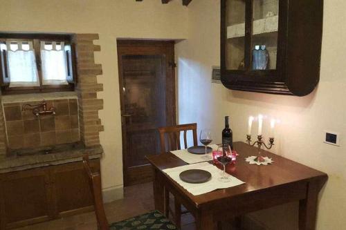 a kitchen with a wooden table with two glasses of wine at Il Borghetto di Pedana in Città di Castello