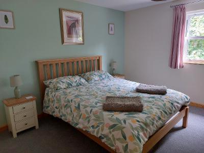 a bedroom with a bed with a wooden headboard and a bed sidx sidx sidx at Two bedroom cottage - country lane -10 min walk to Perranporth beach in Perranporth
