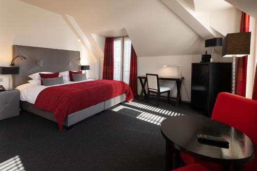 a bedroom with a bed and a table and a chair at Martin's Klooster in Leuven
