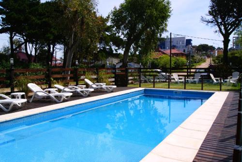 a swimming pool with white lounge chairs at Hotel Europa in Ostende