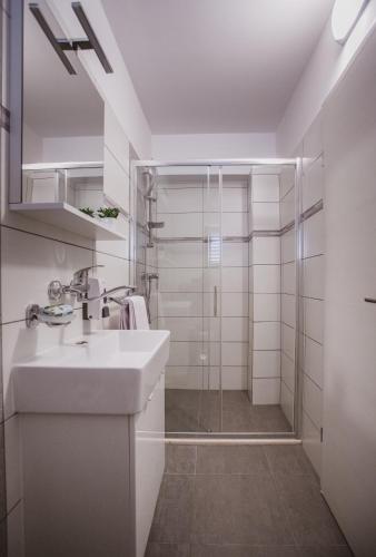 a white bathroom with a sink and a shower at Luxury house Lucija in Dugi Rat
