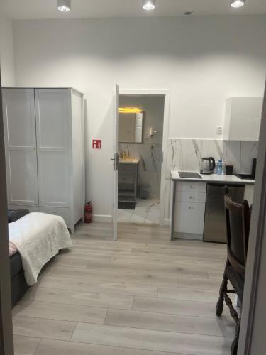 a kitchen with white cabinets and a wooden floor at Apartamenty u Ewy - EUROS in Ustka