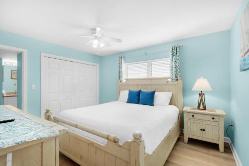 une chambre avec des murs bleus et un lit avec des oreillers bleus dans l'établissement Pelican Isle 301, à Fort Walton Beach