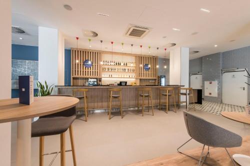 a bar in a restaurant with chairs and tables at Holiday Inn Express Warsaw - Mokotow by IHG in Warsaw