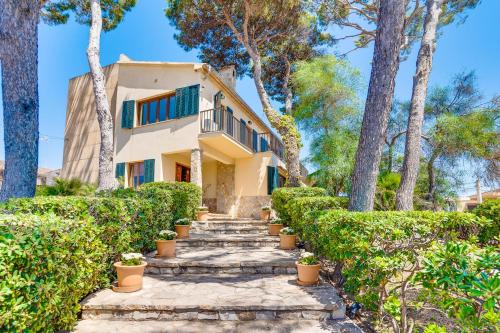a house with trees and stairs in front of it at Villa Cala Estancia Mercedes by PriorityVillas in Palma de Mallorca
