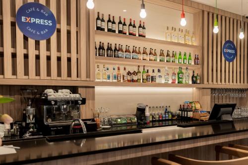 a bar with a lot of bottles of alcohol at Holiday Inn Express Warsaw - Mokotow by IHG in Warsaw