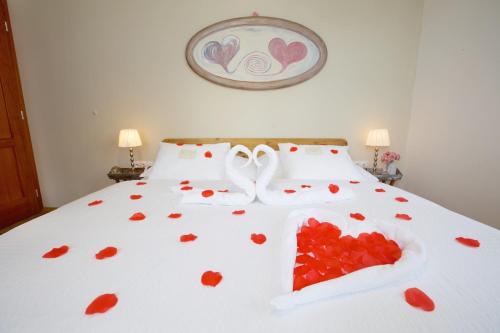 a bed with red hearts on it with two white towels at Wellness Penzion U Muzea in Liberec