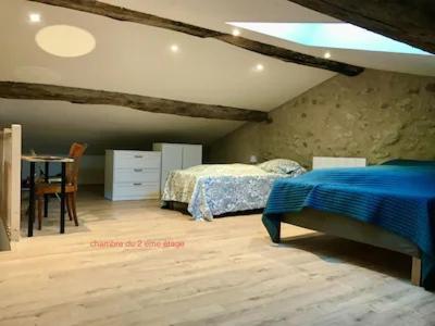 une chambre avec un lit et une table dedans dans l'établissement la maison de Nathalie, à Menglon