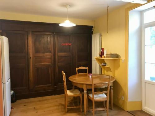 - une cuisine avec une table, des chaises et une porte dans l'établissement la maison de Nathalie, à Menglon