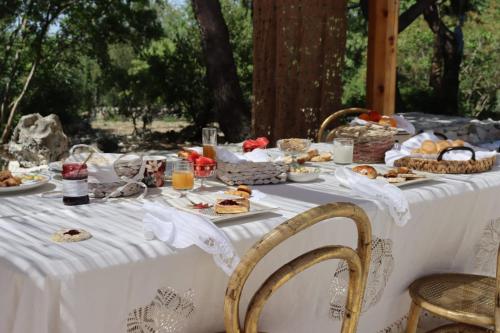 uma mesa com uma toalha de mesa branca com comida em Trullo Sophie in Valle D'Itria SPA Casa Vacanza di Lusso em Ceglie Messapica
