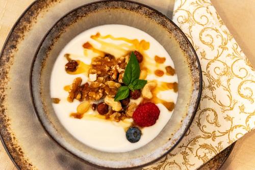 a bowl of cereal with fruit and nuts on a plate at Hochjochstöbli B&B Alpine Easy Stay in Schruns-Tschagguns