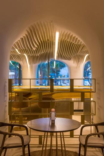 a dining room with a table and chairs at Isla Brown Corinthia Resort & Spa, Curio Collection by Hilton in Agioi Theodoroi
