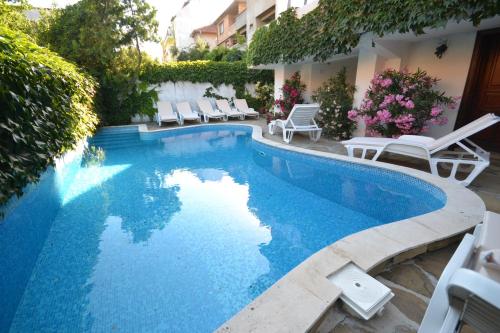 a swimming pool with lounge chairs next to a building at Family Hotel More in Sozopol