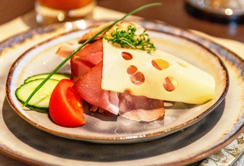 a plate of food with cheese and fruit on a table at Hochjochstöbli B&B Alpine Easy Stay in Schruns-Tschagguns