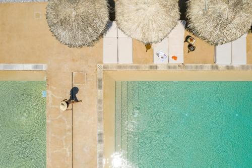 an overhead view of a swimming pool with an overhead at Isla Brown Corinthia Resort & Spa, Curio Collection by Hilton in Agioi Theodoroi