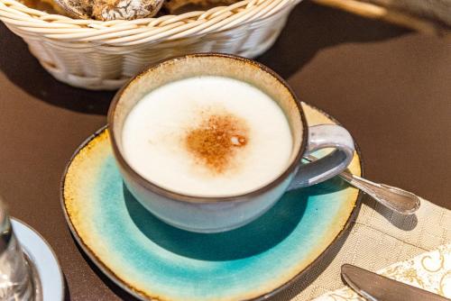 a cup of coffee on a plate on a table at Hochjochstöbli B&B Alpine Easy Stay in Schruns-Tschagguns