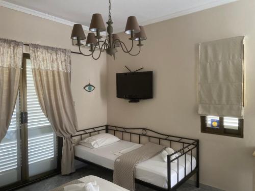 a bedroom with a bed and a tv on the wall at Aelia Houses in Agia Marina Aegina