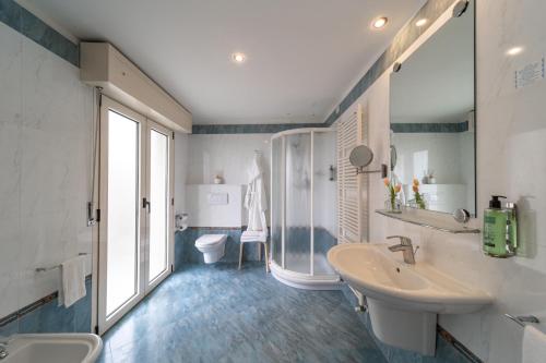 a bathroom with two sinks and a shower and a toilet at Hotel Ancora in Rimini