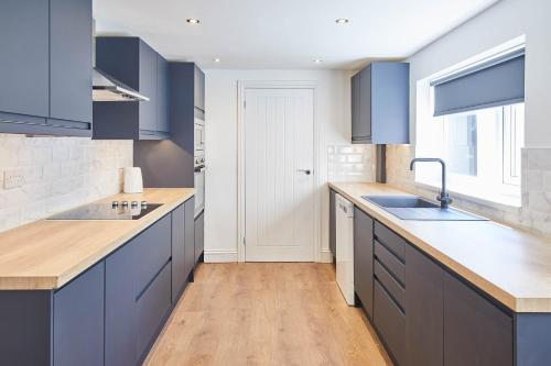 a kitchen with blue cabinets and a sink at Host & Stay - The Lobster Holiday Inn in Redcar