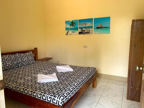 a bedroom with a bed and a picture of the beach at Midnite Inn in Panglao Island
