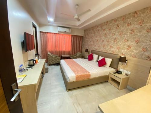 a hotel room with a bed and a desk at Hotel Sagar in Guwahati