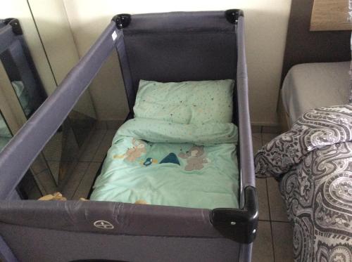 a crib with stuffed animals in it next to a bed at Micheline's plekje in Ostend