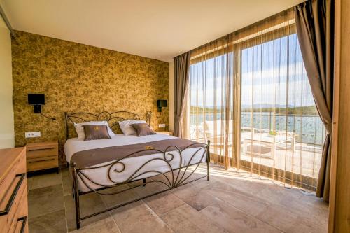 a bedroom with a bed and a large window at Bonaventura Residence in Murter