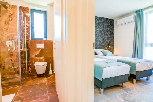 two beds in a room with a shower and a bathroom at Bonaventura Residence in Murter