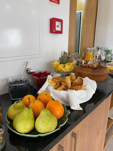 a buffet with pears and other foods on a counter at Quintinha Silvestre in Tondela