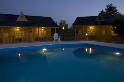 una piscina frente a dos lodges por la noche en Vistalba Lodge en Vistalba