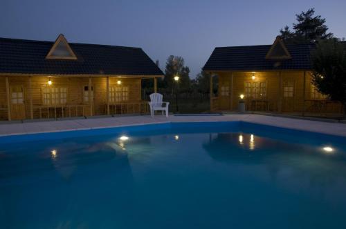 a swimming pool in front of two lodges at night at Vistalba Lodge in Vistalba