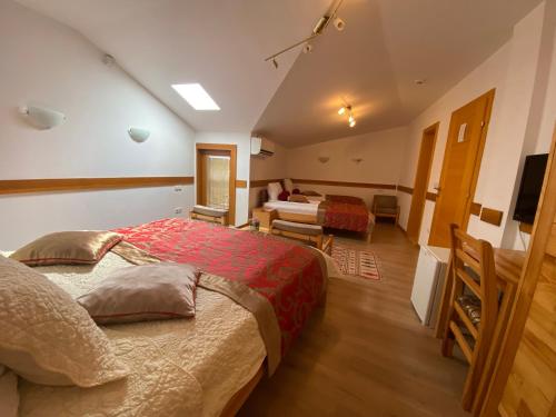a bedroom with a large bed and a living room at Hotel Berr in Sarajevo