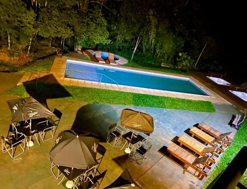 an overhead view of a swimming pool with tables and umbrellas at Rainforest Hotel & Cabañas in Puerto Iguazú