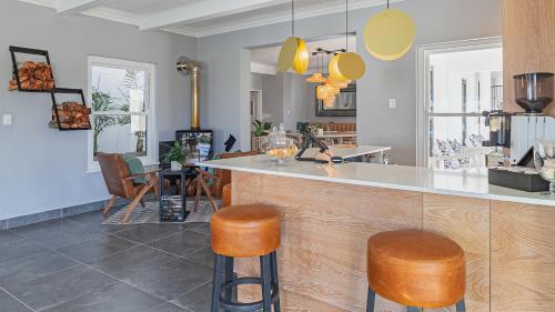 a kitchen with a counter and two stools at The Salene Hotel & Apartments in Stellenbosch