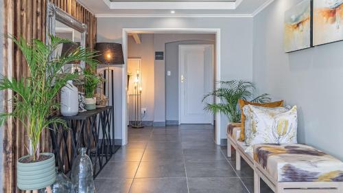a hallway with a couch and potted plants at The Salene Hotel & Apartments in Stellenbosch