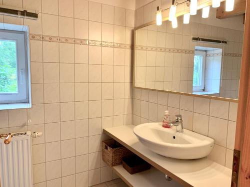 a bathroom with a sink and a mirror at Ferienwohnung 5 im Böhler Haubarg in Sankt Peter-Ording