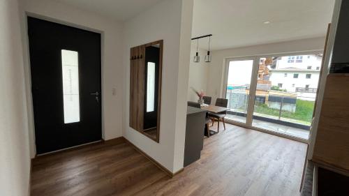 a living room with a black door and a desk at Alpenresidenz M Vermietungs KG in See