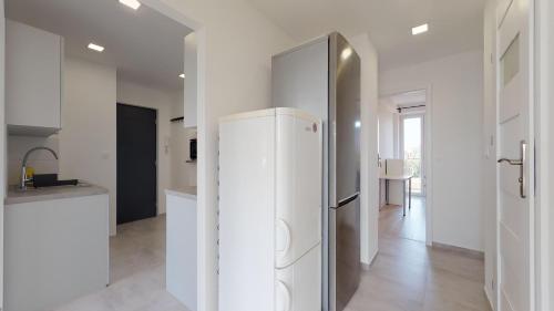 a kitchen with a refrigerator in a white room at Stilo Dom - Plac Grunwaldzki in Wrocław