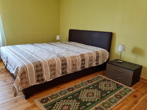 1 dormitorio con cama, mesita de noche y alfombra en Anna Bella Apartman en Gyula