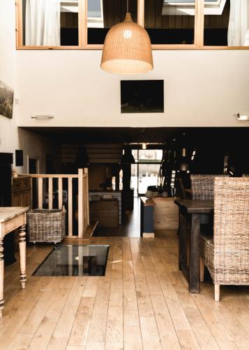 a living room with a glass table and chairs at Il était une fois in Herbeumont