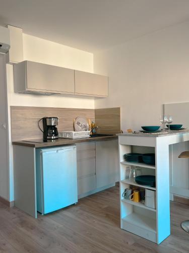 a kitchen with white cabinets and a blue refrigerator at Studio Roncu in Calvi