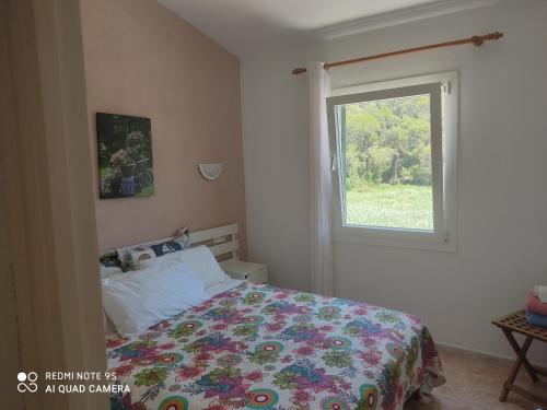 a bedroom with a bed and a window at Cala Galdana Beach in Cala Galdana