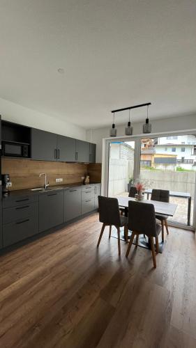 a kitchen with a table and chairs in a room at Alpenresidenz M Vermietungs KG in See