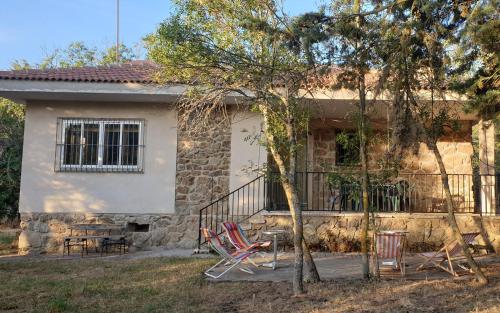 a house with two chairs and a balcony at Casa con Encanto Mitos in Pelayos del Arroyo