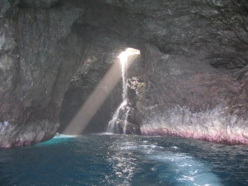 eine Höhle mit einem Wasserfall in der Mitte des Wassers in der Unterkunft West Kauai Lodging in Waimea