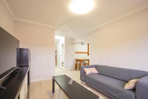 a living room with a couch and a table at El Pico, Apartamento in Ribadesella